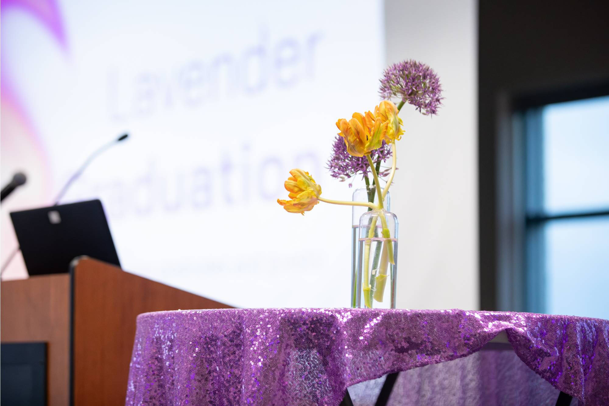 Lavender Graduation with sequined purple tablecloth and a delicate bouquet of purple and yellow flowers